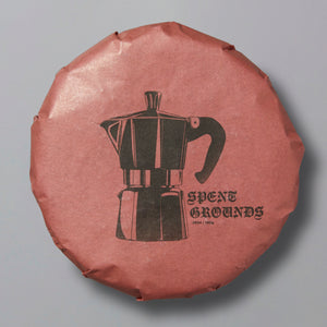 Packaged shou pu'er tea with a graphic of a coffee maker and the brand name 'Spent Grounds' on the top.