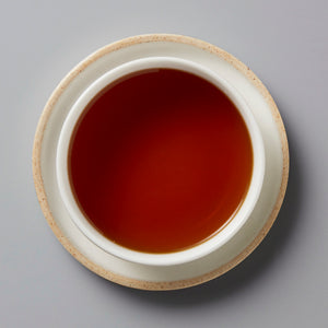 2023 Tree Sap black tea in white ceramic cup showing rich amber-red liquor on grey background