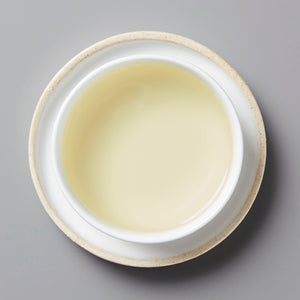 Anshun Maofeng green tea from Guizhou in traditional white ceramic cup showing pale yellow-green liquor