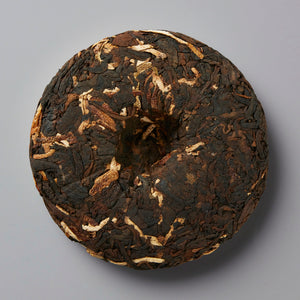 YARD BEER chenpi shou puer tea cake with dark leaves and orange peel flecks pressed into traditional disc shape
