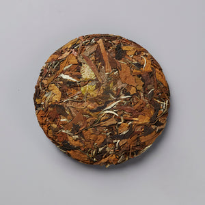 2020 Not From Concentrate white tea cake showing compressed brown and golden tea leaves in circular disc form