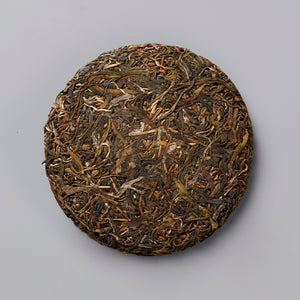 RAWISM 2020 sheng puer tea cake with compressed dark and golden tea leaves in traditional round disc shape