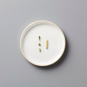 Rainier tisane blend ingredients displayed on minimalist white ceramic plate against grey background