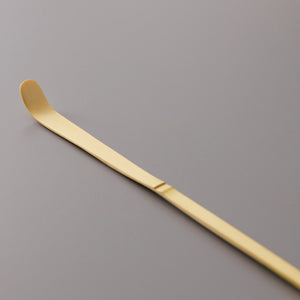 Traditional bamboo Matcha Scoop Chashaku with curved tip for precise tea measuring on grey background