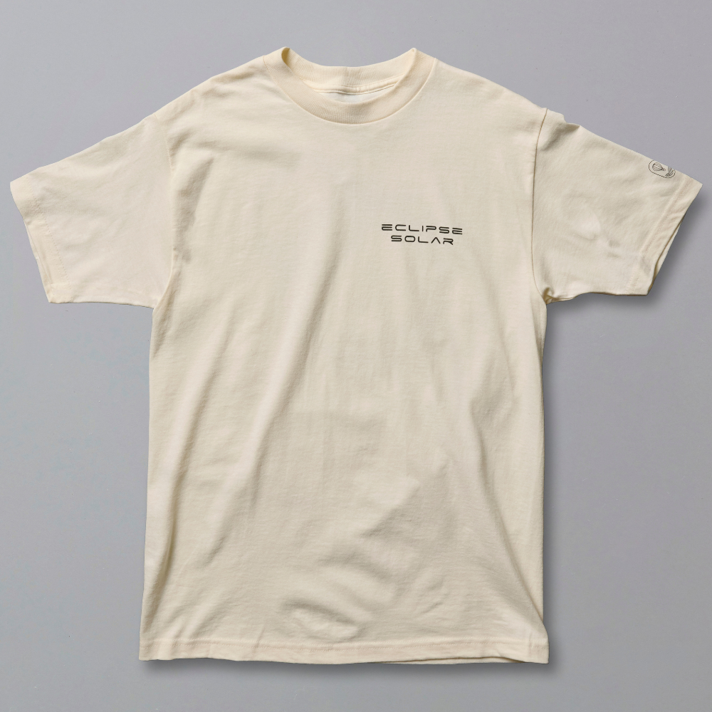An off-white short-sleeve crewneck t-shirt with black Japanese text printed on the left chest, displayed flat against a solid gray background.