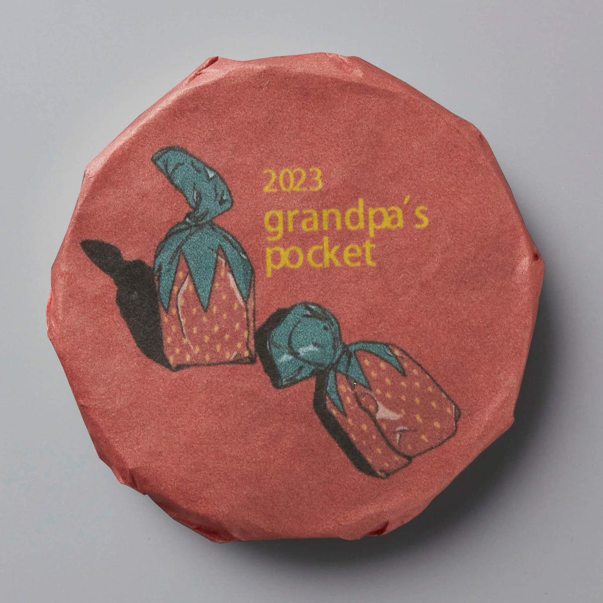 2023 Grandpas Pocket tea cake with illustrated tea bundles on coral-colored wrapper