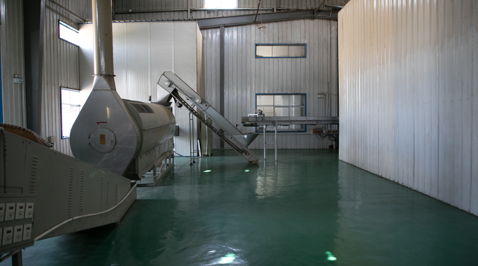 Industrial interior with large tea machinery and conveyor belts in a tea warehouse setting