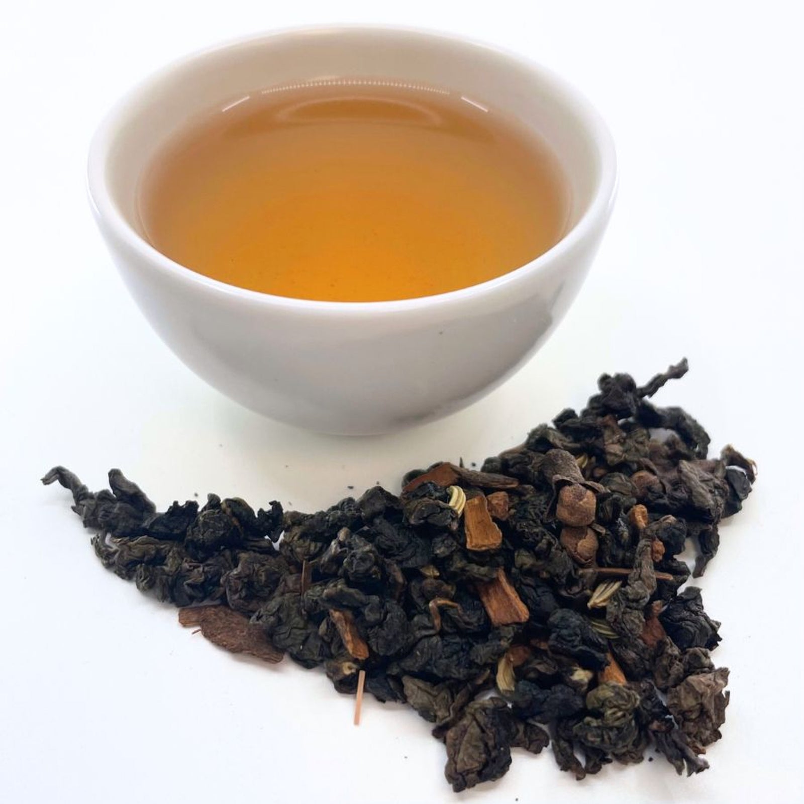 Brewed oolong tea alongside dried oolong leaves showing partial oxidation.