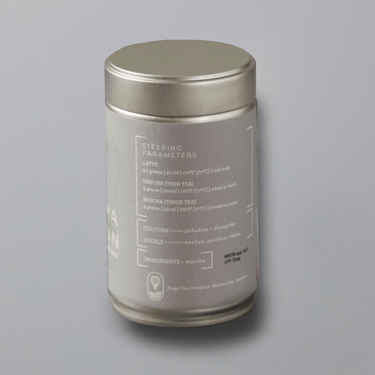 Back-side of matcha Anshun steel tin with text on a gray background