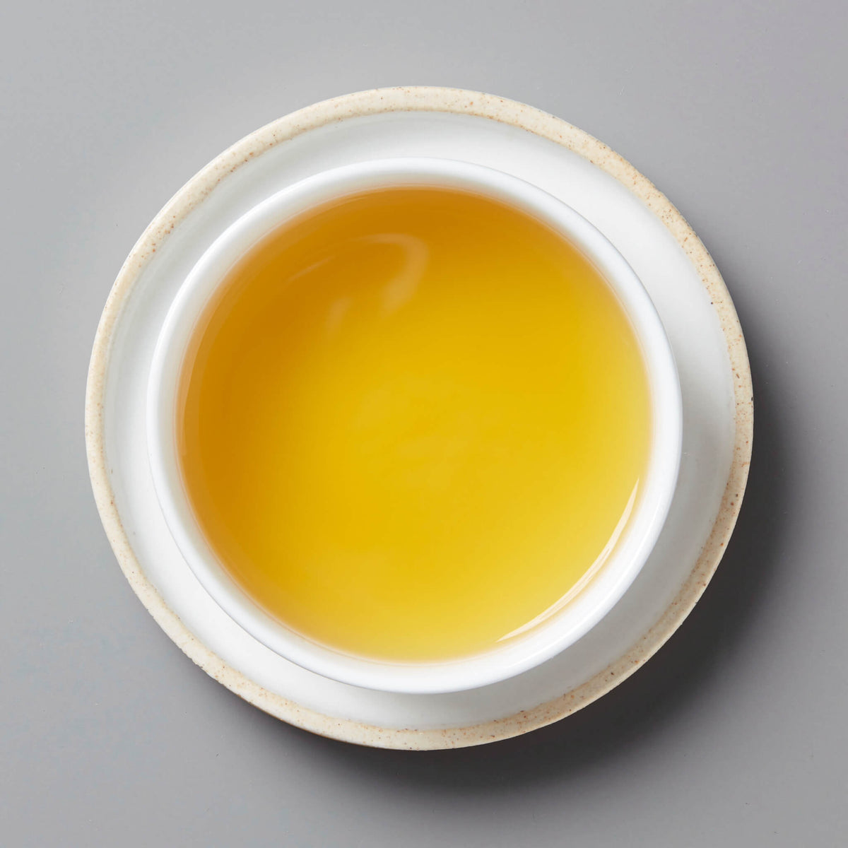 GOLD tisane blend in white ceramic cup showing bright golden yellow liquid from overhead view