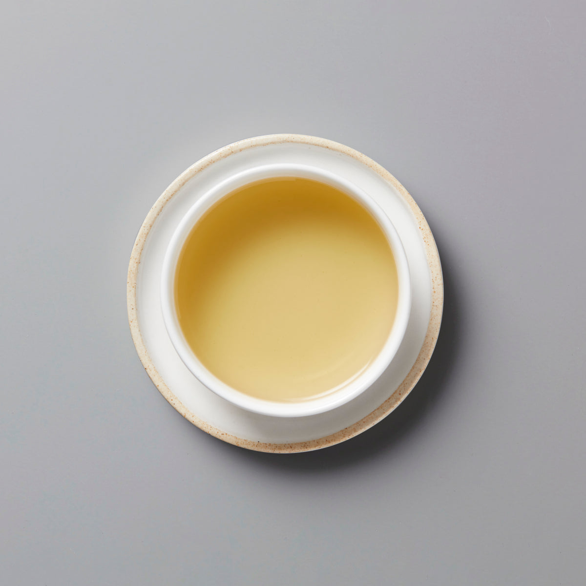 Golden Lins Big Leaf dancong oolong tea in white ceramic cup on gray background