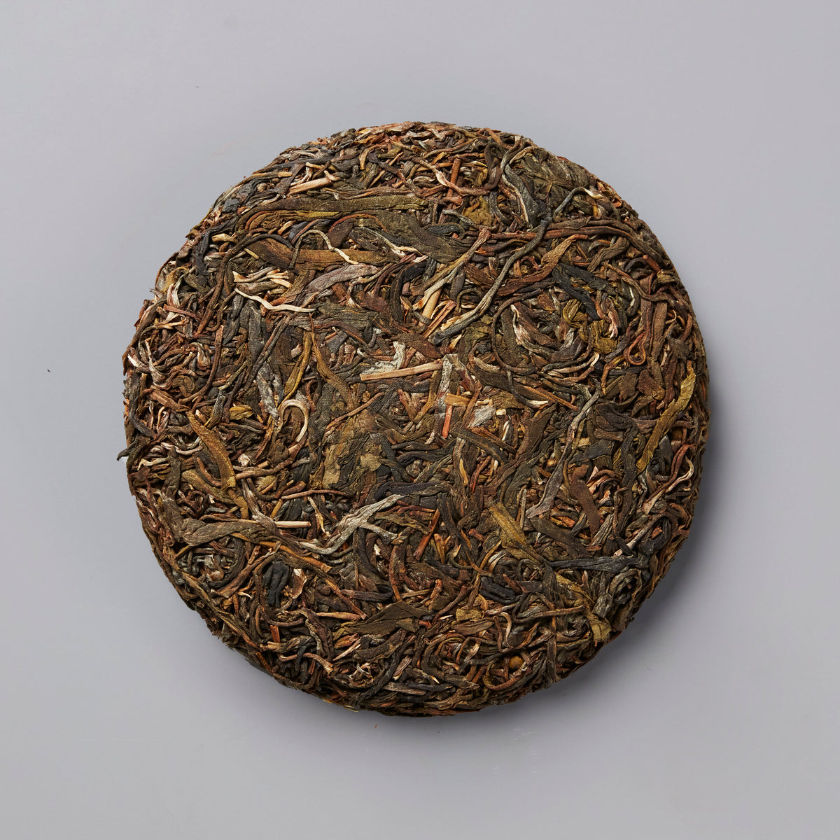 RAWISM 2020 sheng puer tea cake with compressed dark and golden tea leaves in traditional round disc shape
