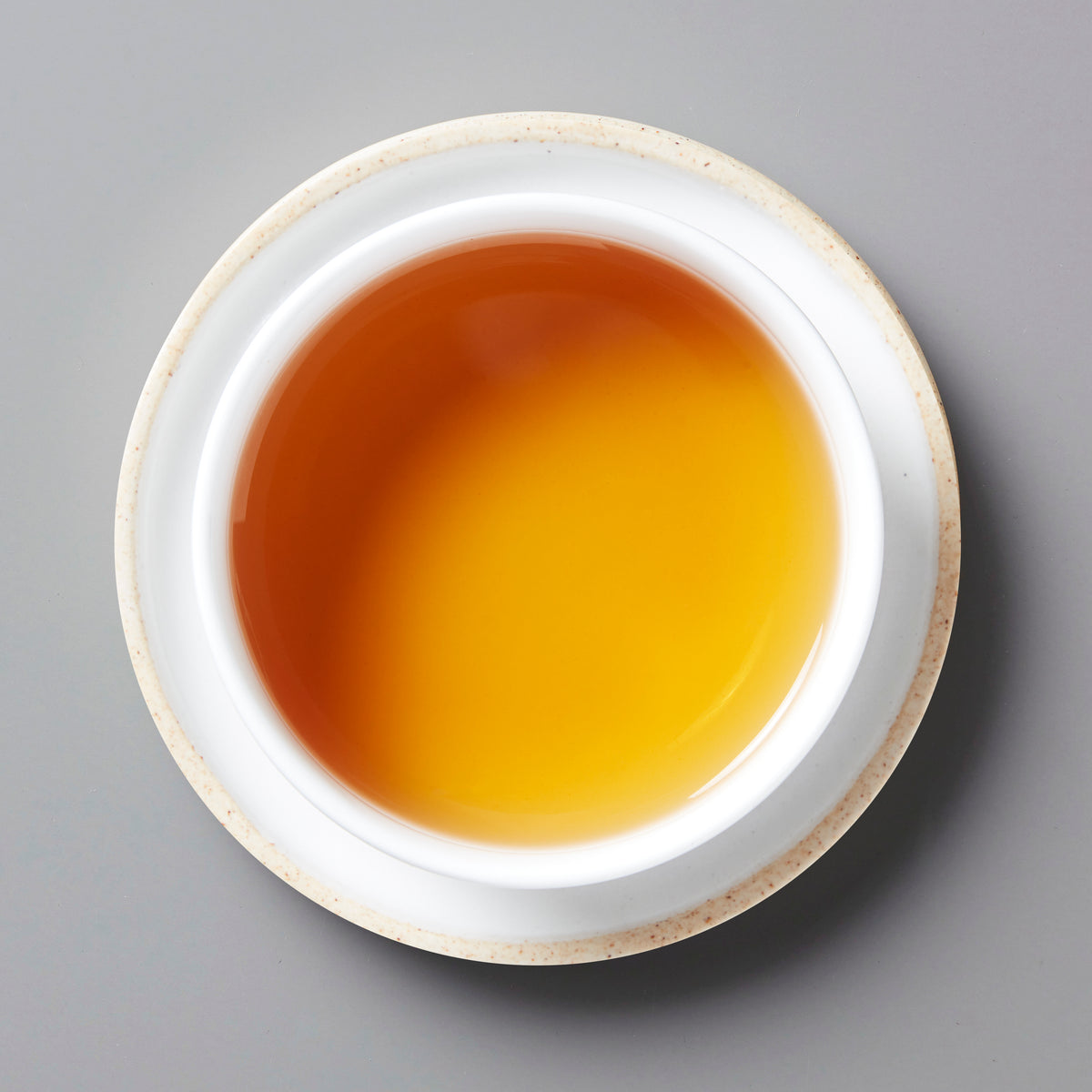 Smoke Break black tea in white ceramic cup showing amber-colored liquid with golden hues