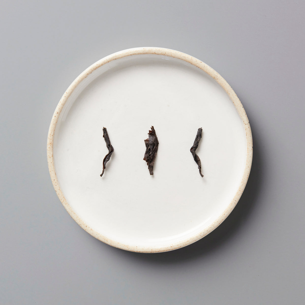 Zi Ran Red black tea leaves artfully arranged on white ceramic plate showing natural twisted leaf form and quality