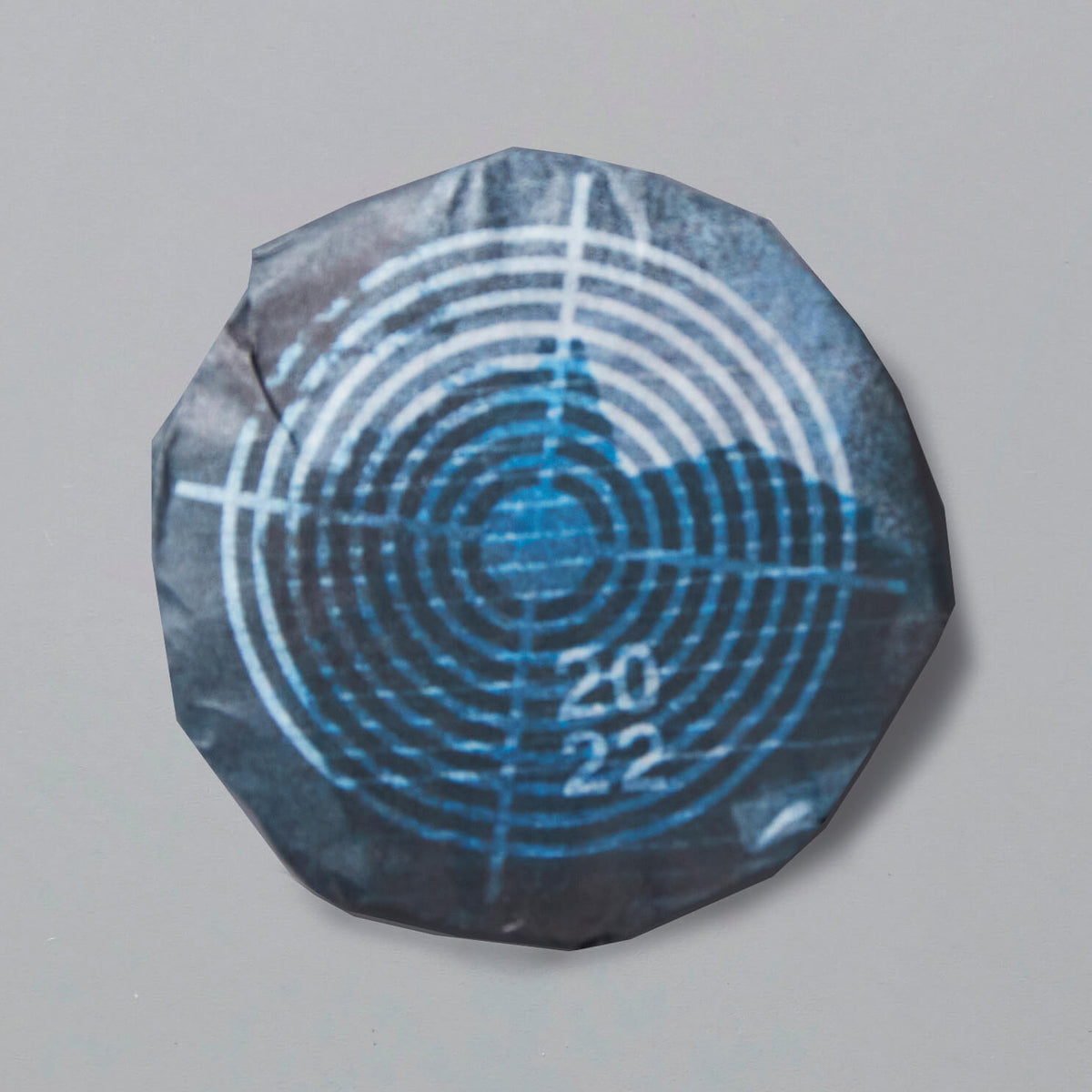 2022 INK JET shou puer tea cake with blue circular target design on dark wrapper